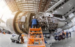 Specialist mechanic repairs the maintenance of a large engine of a passenger aircraft in a hangar.